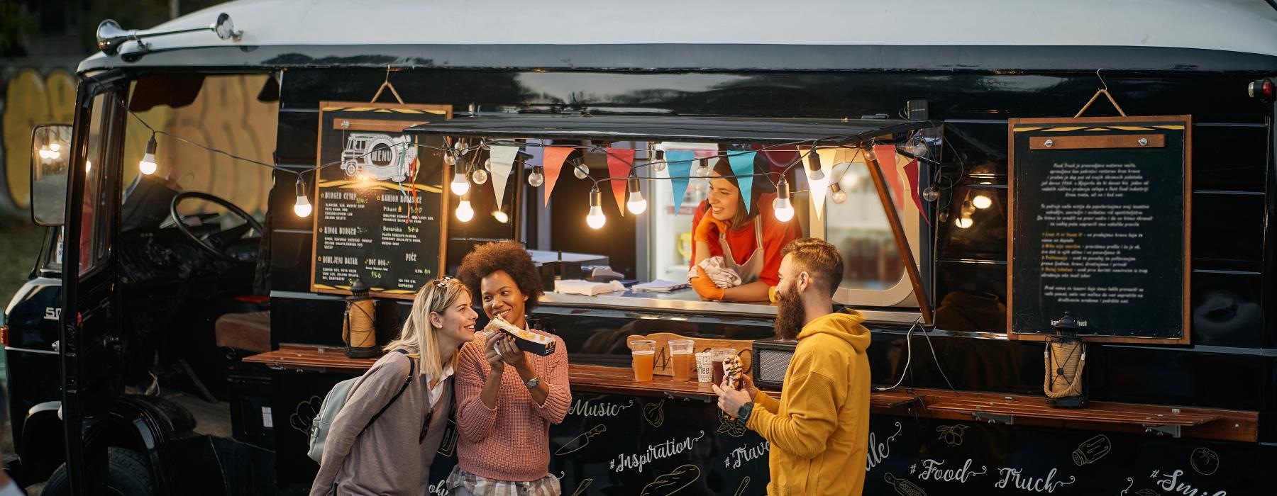 a group of people standing in front of a food truck