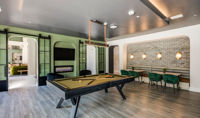 a room with a fireplace and a table with chairs and a tv