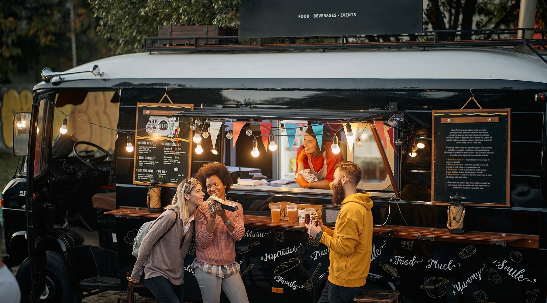 a group of people standing in front of a food truck