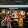 a group of people standing in front of a food truck